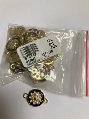 Photo de l’avis officiel: Svart och guldig rund smyckesdel Pendentif — risque: Risque chimique