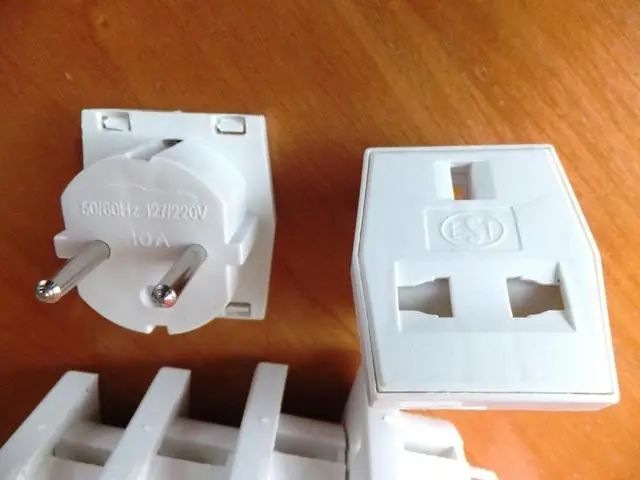Foto aus der offiziellen Meldung: 1. EST, 2.HL-SOUND TECH 1. Multi adaptor            2. Unknown Adapter — Risiko: Elektrischer Schlag & Feuer