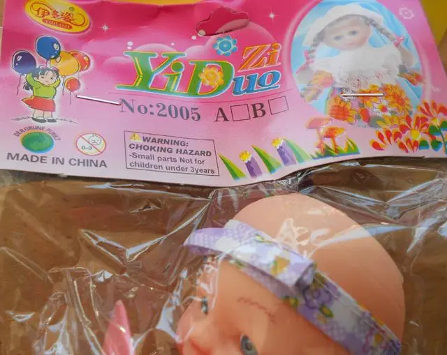 Photo de l’avis officiel: Yiduo Zi Poupée en plastique avec sucette — risque: Risque chimique & Étouffement