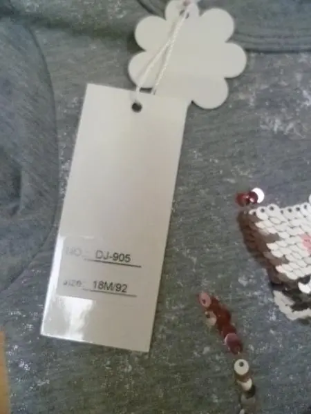 Foto aus der offiziellen Meldung: J.N.S. Kinderkleidungsset — Risiko: Ersticken