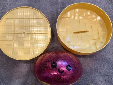 Recalled Mochi Malrang Mystery Dumpling Toy and tan plastic container
