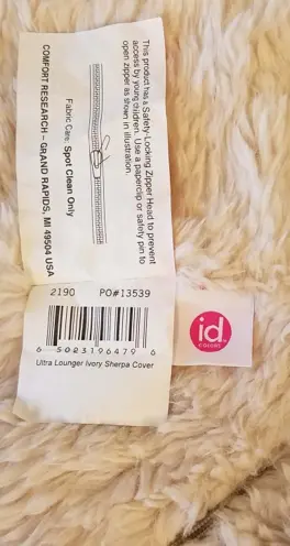 Three sewn-in tags read:  "id COLORS," "RN48711," code "PO#12991" or "PO#13539," the care and use instructions and a warning notice.