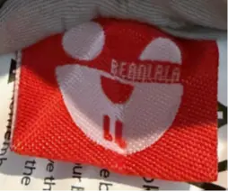 "Bearlala" is printed on an attached label on the outside of the recalled baby lounger's cover