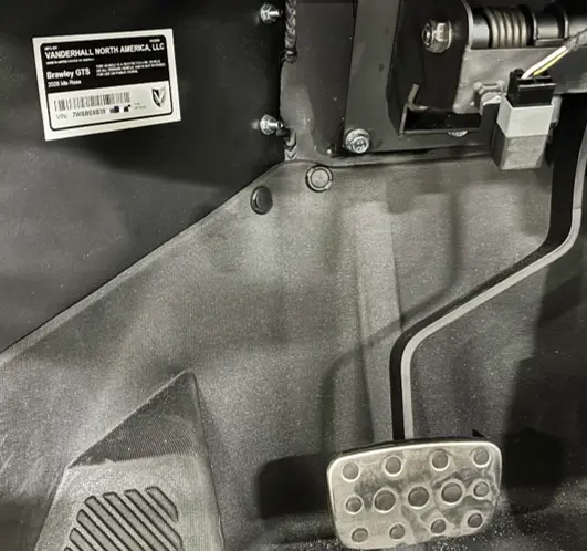 The VIN is visible underneath the driver-side dashboard, left of the foot pedals