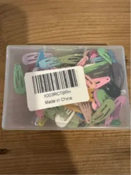 Recalled Dlesot Snap Hair Clips in plastic container with label