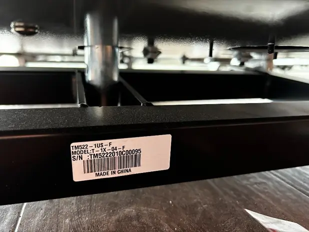 Location of model name and the serial number on the connecting bar at the bottom of the treadmill