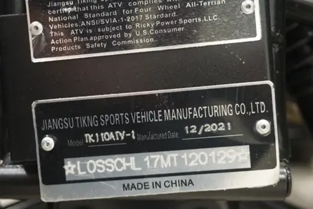 The youth ATV's model number appears on a plate located at the front of the vehicle between the two front tires