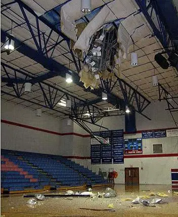 Stadium light pole fallen through gymnasium roof